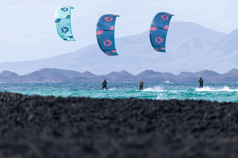Duotone Neo LEI kite durante il surf sulle onde in una laguna oceanica con costa vulcanica