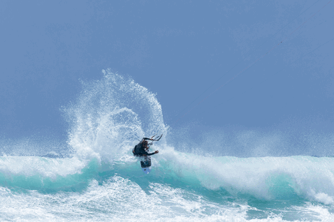 Duotone Fish SLS kite surfboard during kitesurfing at the ocean beach in steel blue