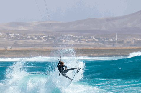 Duotone Fish SLS kite surfboard during wave riding at the ocean coastline