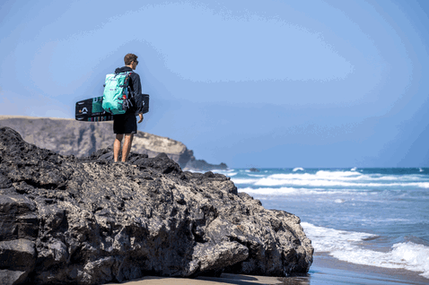 Duotone Dice LEI Kite beim Kitesurfen an felsiger Küste mit Ozeanwellen