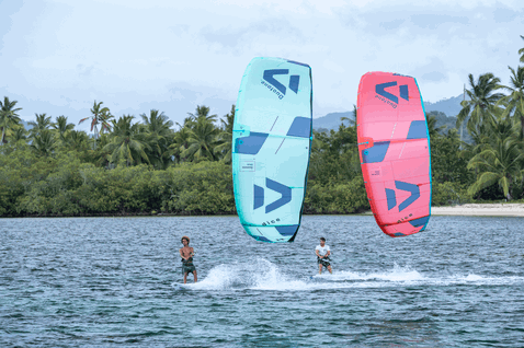 Duotone Dice LEI Kite beim Kitesurfen in einer tropischen Lagune mit Palmen und Sandstrand in petrol, korallrot und marineblau