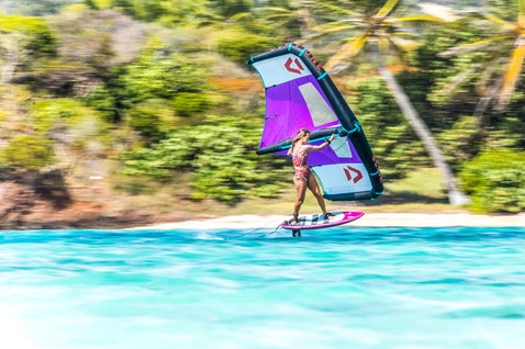Duotone Slick Foilwing beim Wing Foiling in einer tropischen Lagune in lila und weiß