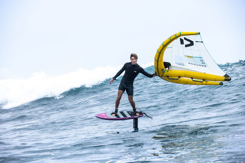 Duotone Unit D/LAB foil wing durante il wing foiling in oceano in giallo e ciano
