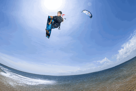 Duotone Evo LEI kite durante il kitesurf sulla spiaggia oceanica in blu acciaio