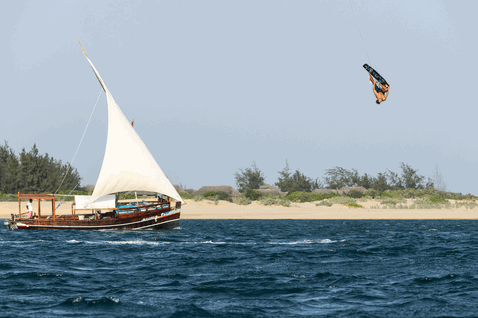 Aquilone LEI Duotone Evo durante il kitesurf su spiaggia oceanica con sabbia e alberi