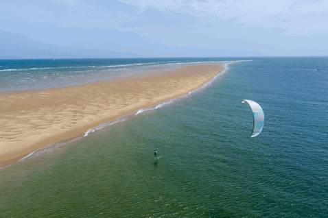 Duotone Juice LEI kite durante il kitesurf su una spiaggia oceanica