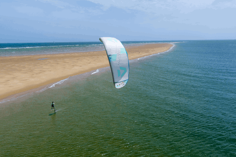 Duotone Juice LEI kite durante il foiling su una spiaggia oceanica con bassifondi