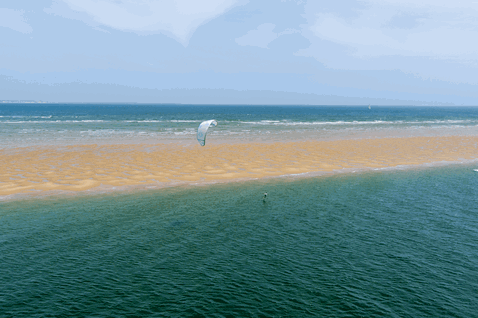 Duotone Juice LEI kite durante il kitesurf su una spiaggia oceanica con banco di sabbia tidale