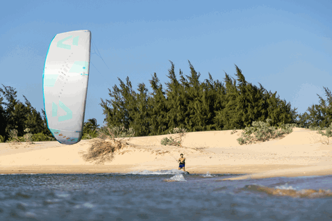 Duotone Juice LEI kite durante il kitesurf in una laguna con spiaggia sabbiosa