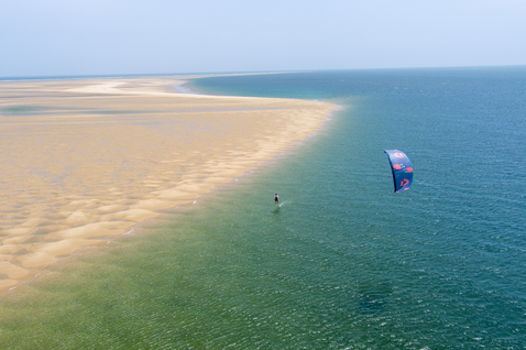 Duotone Mono LEI kite durante il kitesurf in acque costiere basse con spiaggia sabbiosa