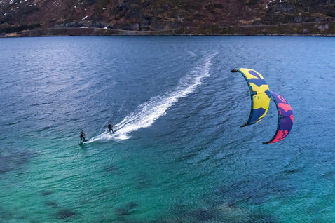 Duotone Dice SLS LEI kite during kitesurfing at a mountain fjord in deep navy blue