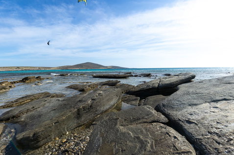 Duotone Dice SLS LEI kite during kitesurfing at a rocky coastal shoreline and ocean bay
