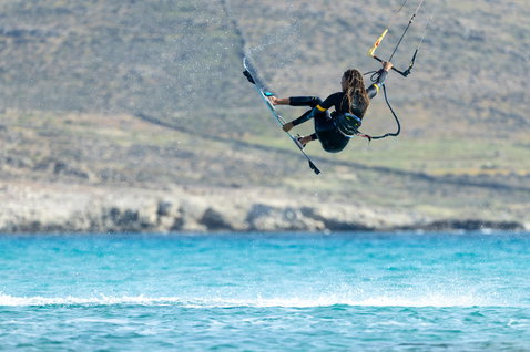 Duotone Click Bar Quad Control Select Control Bar beim Kitesurfen an der Meeresküste mit Felshügeln