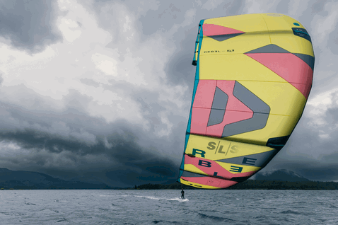 Aquilone LEI Duotone Rebel SLS 6m durante il kitesurf su un lago con sfondo montano