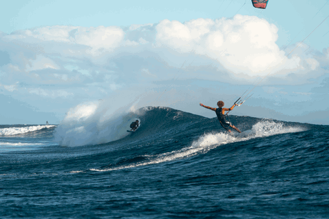 Duotone Neo SLS LEI kite durante il wave riding su una spiaggia oceanica in blu oceano profondo