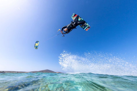 Duotone Select kiteboard twin-tip durante kitesurf su una spiaggia oceanica