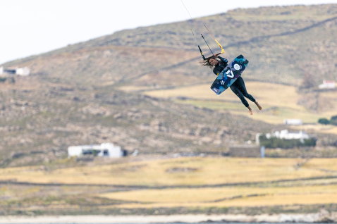 Duotone Soleil SLS twin-tip kiteboard lors du kitesurf dans un lagon côtier avec un arrière-plan de collines arides