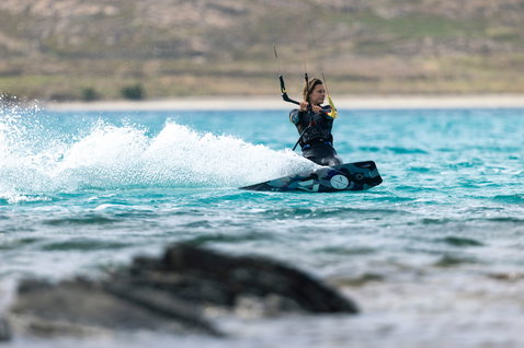 Duotone Soleil SLS kiteboard twin-tip en train de faire du kitesurf sur la plage océanique