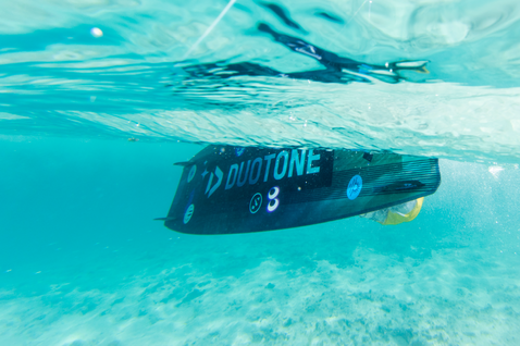 Duotone Shred twin-tip kiteboard while kitesurfing in shallow tropical ocean