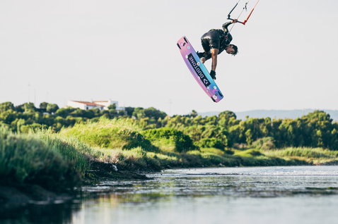 Duotone Team Series twin-tip kiteboard during kitesurfing in a lagoon with dense green vegetation