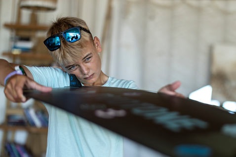 Duotone Shred twin-tip kiteboard during standing pose in an indoor beach shack or kite school setting