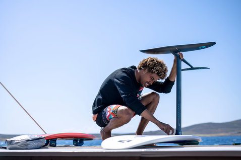 Duotone Hybrid SLS kiteboard while foiling on the ocean from a dock