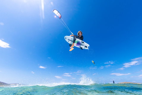 Duotone Fish D/LAB 2024 Kite-Surfboard beim Kitesurfen an einer tropischen Felsenküste