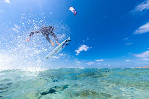 Duotone Fish D/LAB Kite-Surfboard beim Kitesurfen im tropischen Ozean über flachem Riff