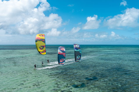 Duotone Evo SLS LEI Kite beim Kitesurfen in einer tropischen Lagune mit türkisblauem Wasser und Korallenriff