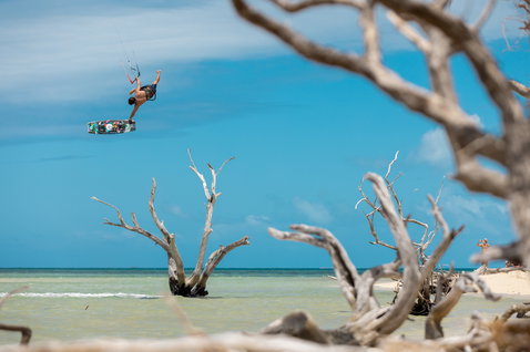 Duotone Evo SLS LEI Kite beim Kitesurfen an einem tropischen Strand mit türkisblauem Flachwasser