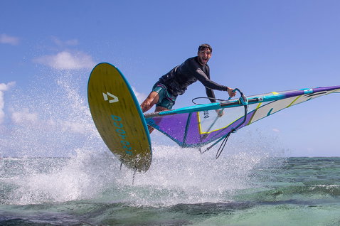 Duotone FreeWave SLS windsurf board during wave riding at a tropical ocean reef