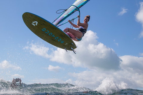Duotone FreeWave SLS 2024 windsurf board during wave riding in the ocean near coastal cliffs