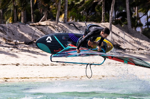 Duotone Skate SLS 2024 windsurf board during freestyle windsurfing at a tropical beach with turquoise water
