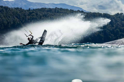 Duotone Gambler wake-style kiteboard during kitesurfing on a mountain lake