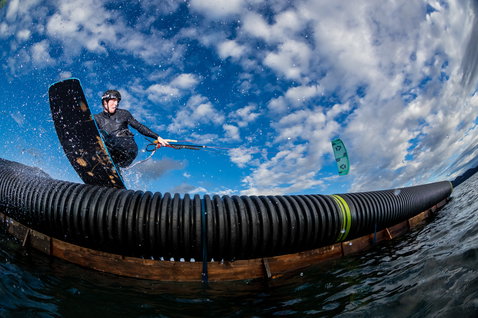 Duotone Gambler wake-style kiteboard during wakestyle riding at a lake with wake park feature