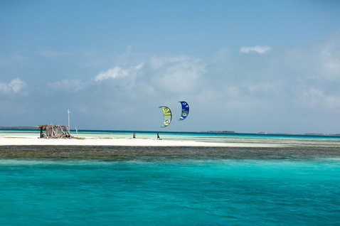 Duotone Rebel SLS LEI kite lors d'une session de kitesurf sur un banc de sable tropical avec océan turquoise