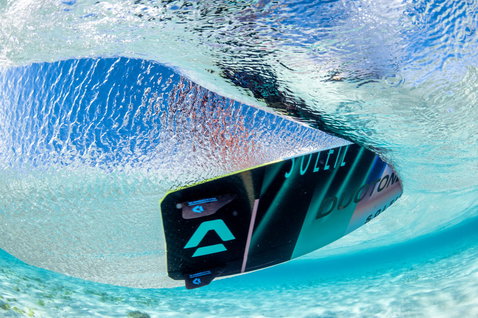 Duotone Soleil Concept Blue twin-tip kiteboard during kitesurfing in clear shallow water of a tropical ocean