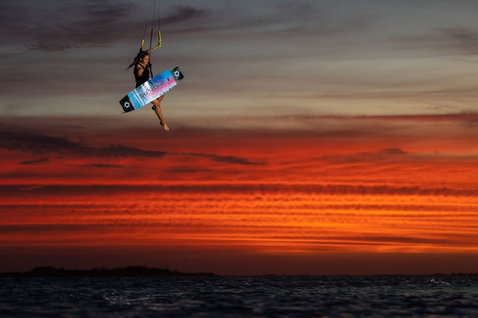 Duotone Soleil SLS twin-tip kiteboard during kitesurfing on the ocean beach at sunset