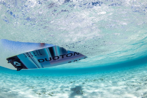 Duotone Soleil SLS twin-tip kiteboard during kitesurfing in tropical ocean with shallow sandy bottom
