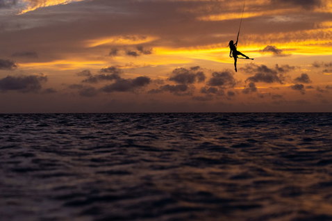 Duotone Soleil SLS twin-tip kiteboard during kitesurfing in the open ocean at sunset
