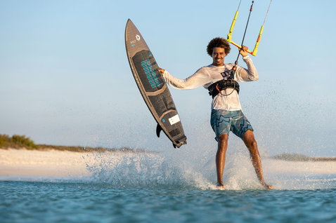 Tabla de kitesurf Duotone Volt SLS Concept Blue durante kitesurf en una playa tropical de aguas poco profundas