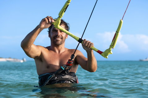 Duotone Click Bar Quad Control 2024 control bar during kitesurfing on a tropical ocean beach