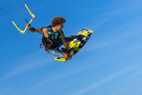 Duotone Kiteboarding Entity Ergo 2024 twin-tip kiteboard during kitesurfing on the open ocean under blue sky