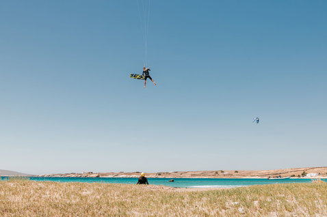 Duotone Kiteboarding Entity Ergo 2024 twin-tip kiteboard during kitesurfing at a coastal lagoon with turquoise water