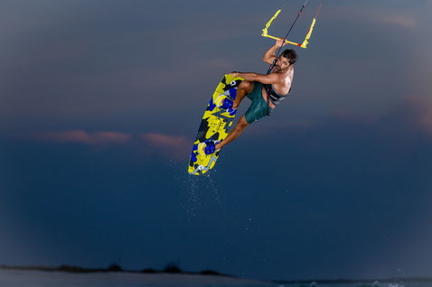 Duotone Entity Ergo 2024 twin-tip kiteboard during kitesurfing on an ocean beach