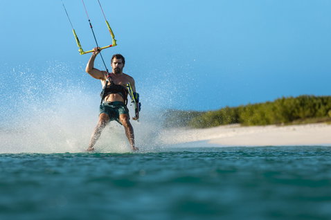 Duotone Entity Ergo 2024 twin-tip kiteboard during kitesurfing at a tropical lagoon beach