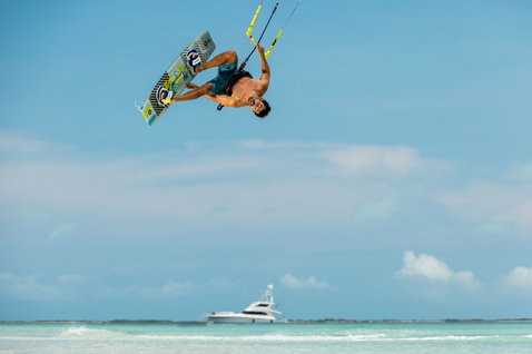 Duotone Vario Combo Select twin-tip kiteboard pendant le kitesurf sur la plage tropicale de l'océan