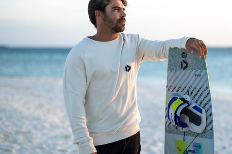 Duotone Vario Combo Concept Blue twin-tip kiteboard en position debout sur la plage de l'océan