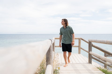 Duotone Apparel Shirt Wave SS Unisex Kurzarmhemd beim Tragen am Ozeanstrand in staubigem oliv