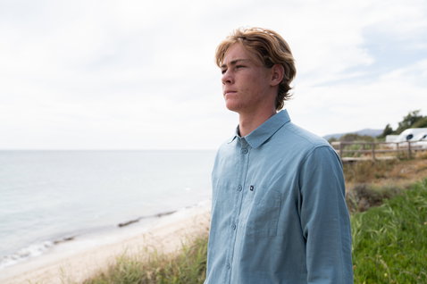 Duotone Apparel Shirt Breeze LS unisex long sleeve shirt in blue fog during a standing pose on an ocean beach